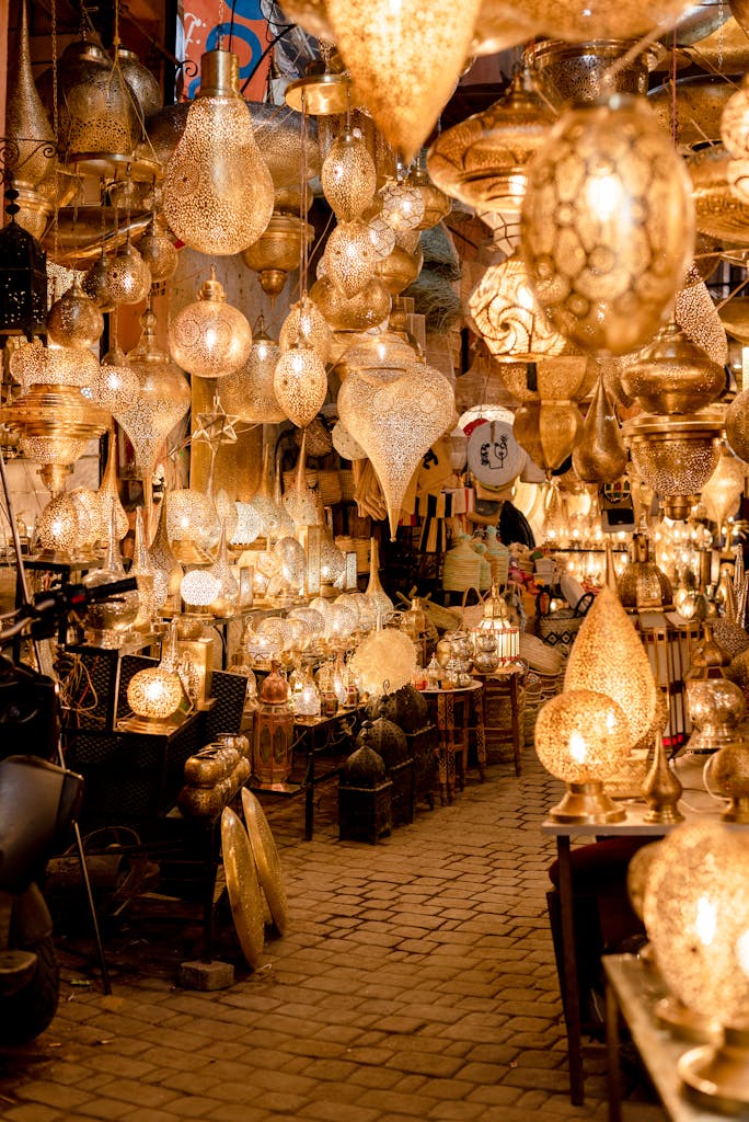A vibrant display of traditional Moroccan hanging lamps in a Marrakech souk, glowing with golden light.