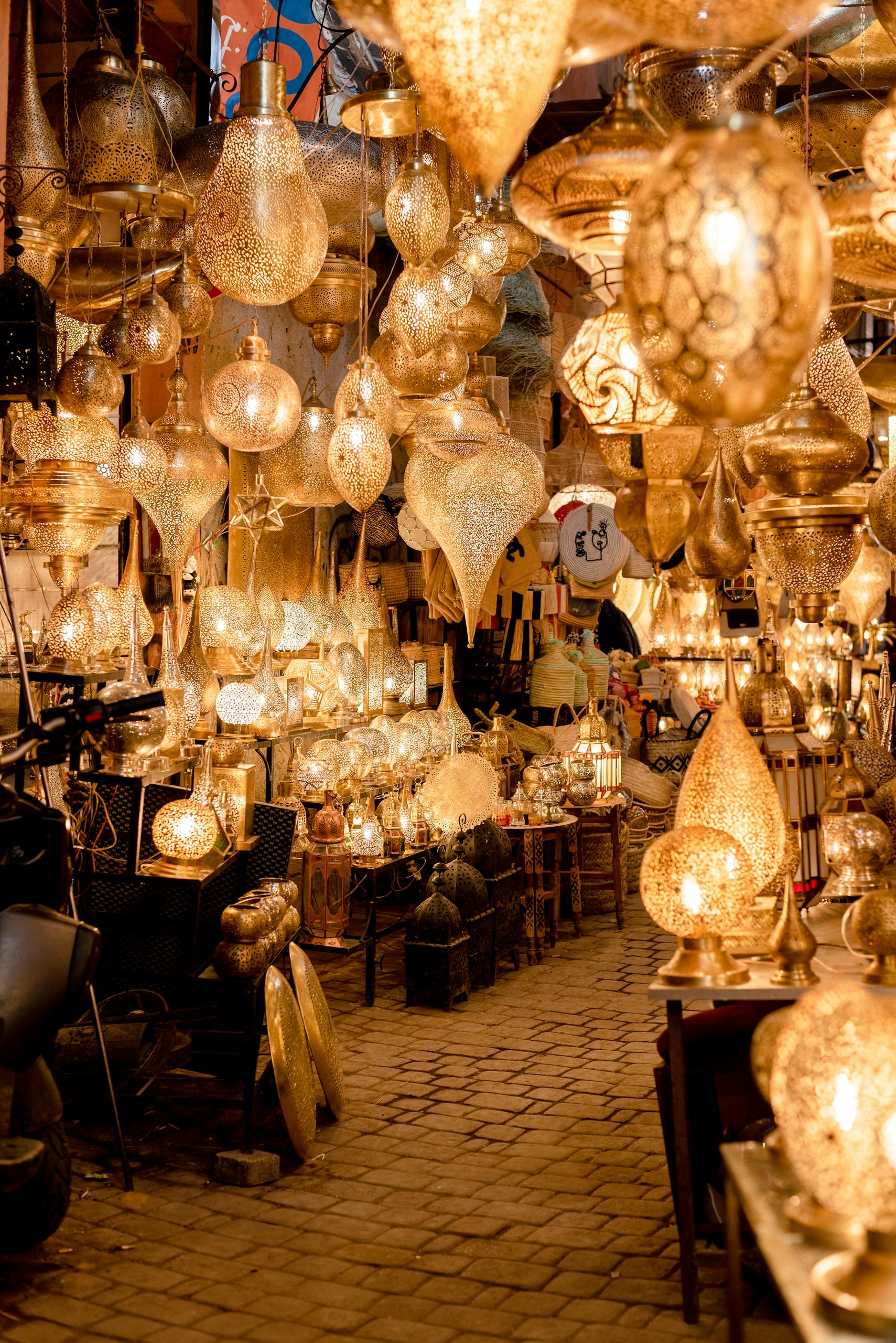 A vibrant display of traditional Moroccan hanging lamps in a Marrakech souk, glowing with golden light.