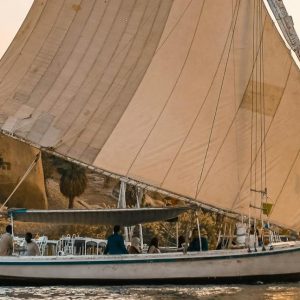 Scenic view of a traditional Egyptian felucca sailing at sunset on the Nile.