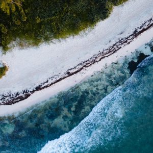 A breathtaking aerial shot of Tulum's beach with waves crashing on the shore.