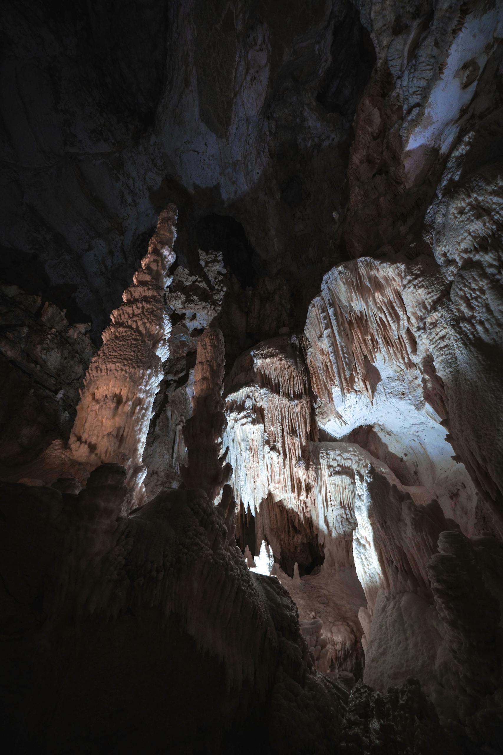 Explore the natural beauty of an eroded cave interior showcasing dramatic stalactites and stalagmites.